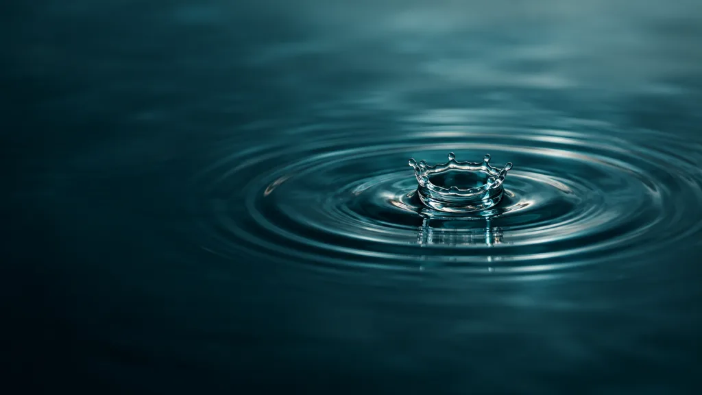 Water drop hitting a still surface and forming ripples